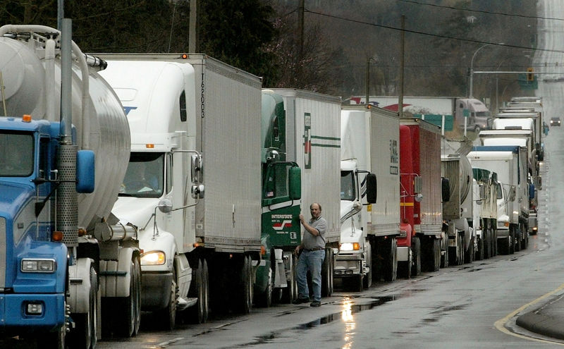 © Reuters. FILE PHOTO - Trucks waiting to cross the Canadain border into the United States line up in Surrey, British Columbia