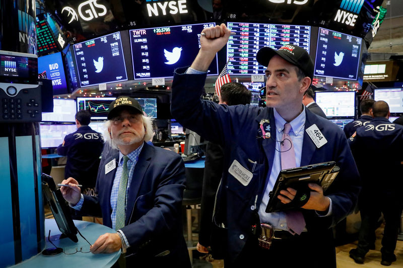 © Reuters. FILE PHOTO: Traders react at the closing bell on the floor of the NYSE in New York