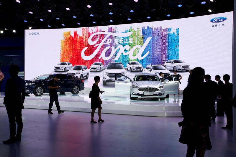 © Reuters. FILE PHOTO: Visitors look at Ford models at Auto Guangzhou in Guangzhou