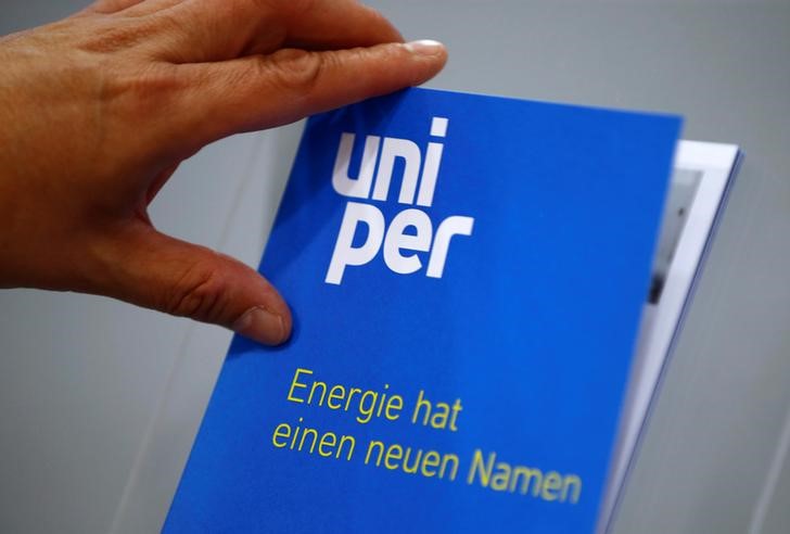 © Reuters. A shareholder of E.ON SE Climate and Renewables picks up a brochure of E.ON's utility sector Uniper SE in Essen