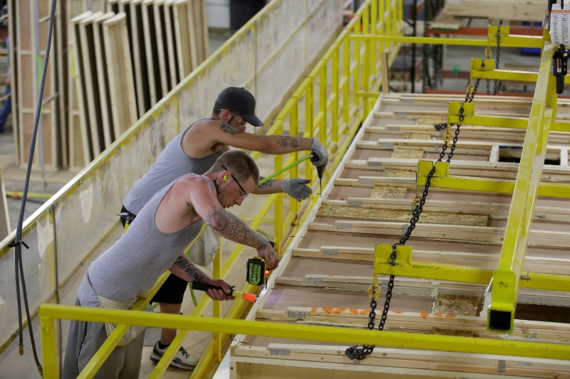 © Reuters. FILE PHOTO: Workers build the roof of a single axel towable Pioneer traditional recreational vehicle in Elkhart