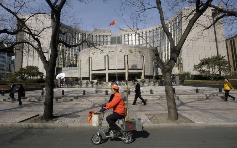 © Reuters. People past the headquarters of the central bank of the People's Republic of China in Beijing