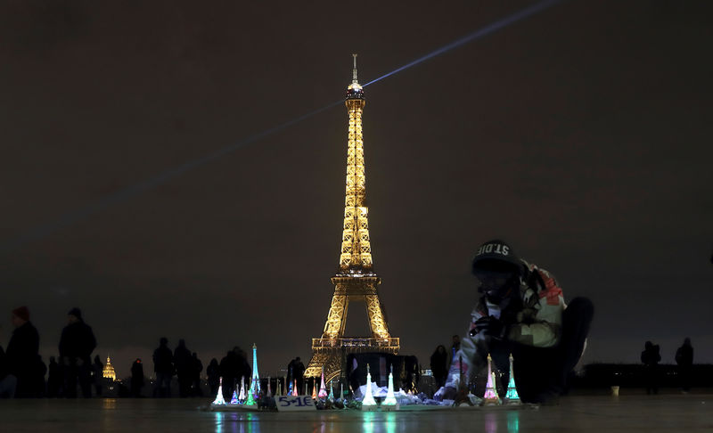 © Reuters. A souvenir vendor sells Eiffel tower models at Trocadero square near the Eiffel Tower in Paris
