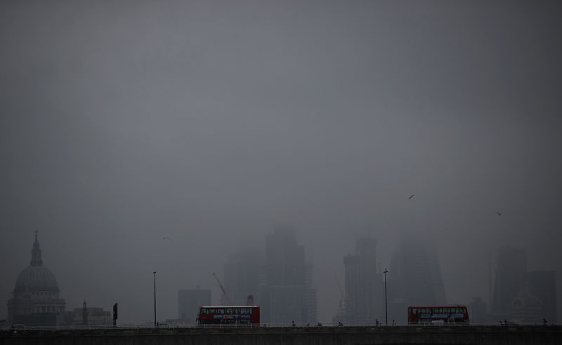© Reuters. FILE PHOTO: The City of London is partly obscured by morning fog, in London