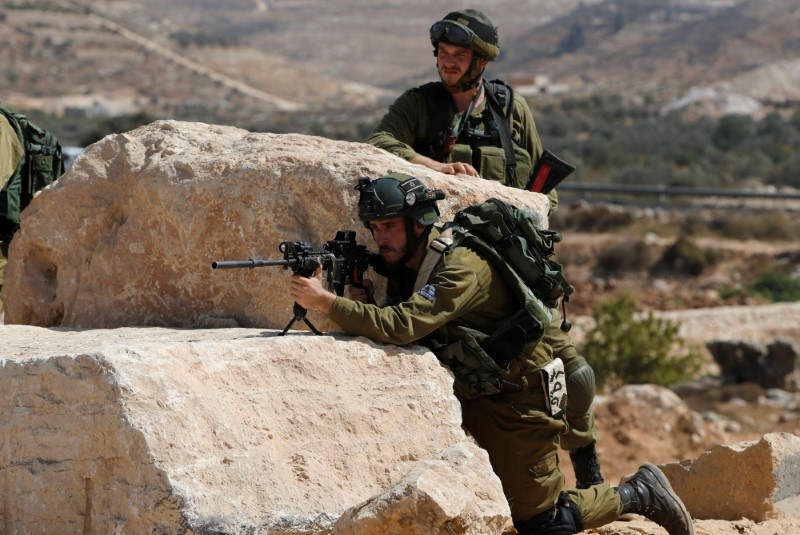 © Reuters. Soldado israelense aponta arma na cidade de Hebrom, na Cisjordânia