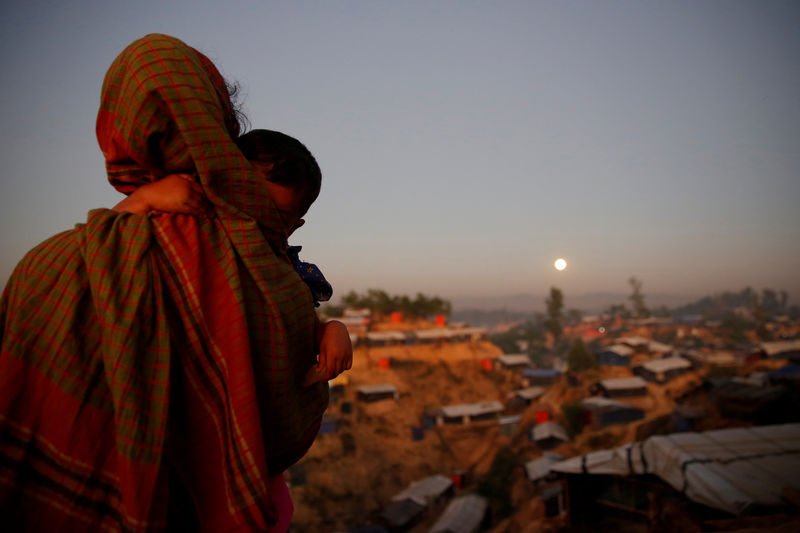 © Reuters. A Rohingya refugee looks at the full moon with a child in tow at Balukhali refugee camp near Cox's Bazar