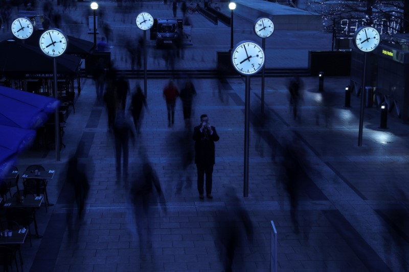 © Reuters. FILE PHOTO -  Workers walk to work during the morning rush hour in the financial district of Canary Wharf in London