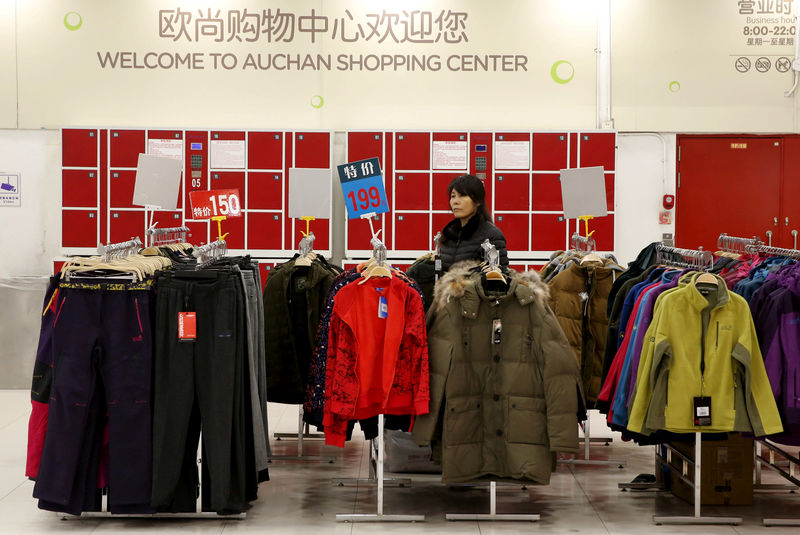 © Reuters. FILE PHOTO: An employee waits for customers at Sun Art Retail Group's Auchan hypermarket store in Beijing