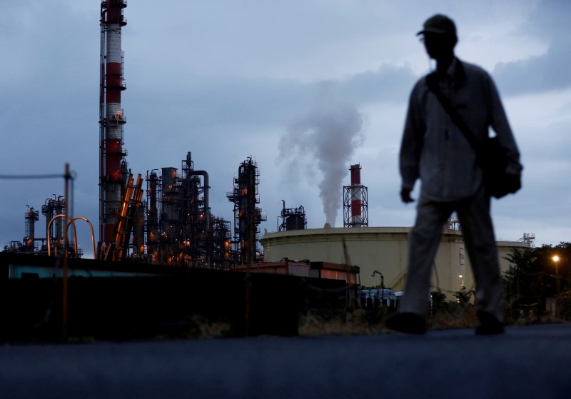 © Reuters. FILE PHOTO: A man walks past a factory at the Keihin industrial zone in Kawasaki