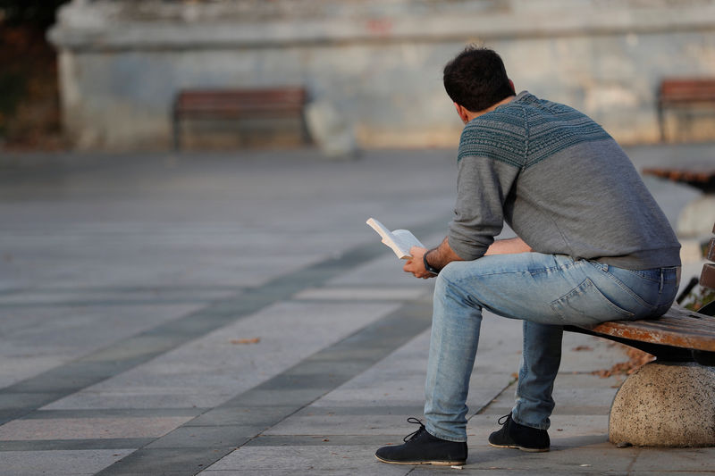 © Reuters. Alireza, an Iranian refugee living in Turkey, reads a book at a park in central Istanbul