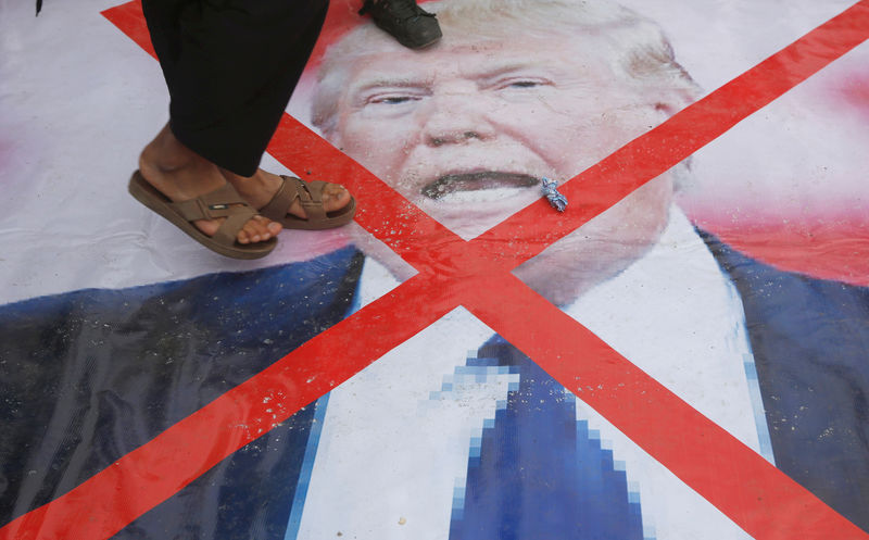 © Reuters. Manifestante pisa sobre foto do presidente dos Estados Unidos, Donald Trump, durante protesto contra o reconhecimento de Jerusalém como capital de Israel em Cabul, Afeganistão