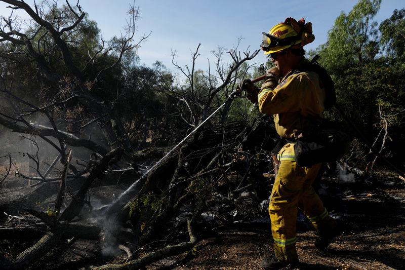 © Reuters. Bombeiro trabalha para conter incêndio em Bonsall, Califórnia