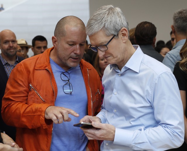 © Reuters. FILE PHOTO - Apple CEO Cook plays with an iPhone during a launch event in Cupertino