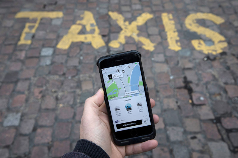 © Reuters. FILE PHOTO: A photo illustration shows the Uber app on a mobile telephone, as it is held up for a posed photograph, in London