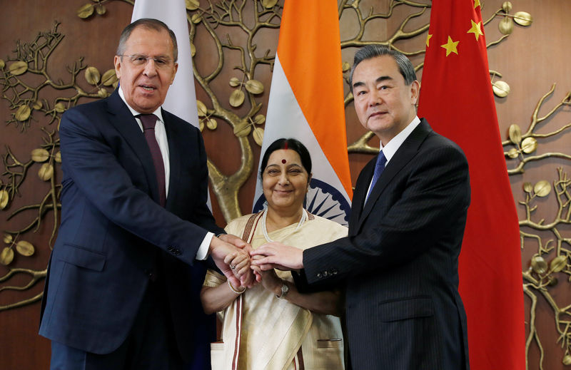 © Reuters. Russian Foreign Minister Lavrov Indian Foreign Minister Swaraj  and Chinese Foreign Minister Wang Yi shake hands before the start of their meeting in New Delhi