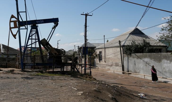 © Reuters. Нефтяной насос-качалка в поселении недалеко от Баку