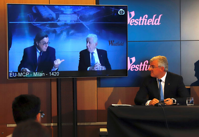 © Reuters. Westfield Chairman and co-founder Frank Lowy and his son Peter talk via video-link as his other son Steven Lowy listens on during a media conference in Sydney
