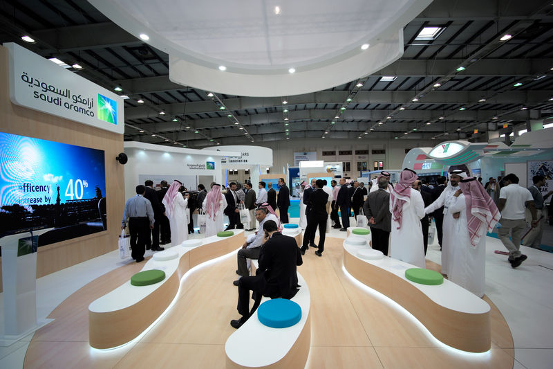 © Reuters. FILE PHOTO: Visitors are seen at the Saudi Aramco stand at the Middle East Process Engineering Conference & Exhibition in Manama