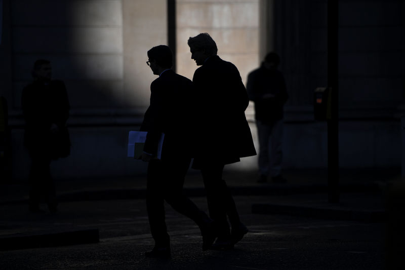 © Reuters. Two men silhouetted as they walk past the Bank of England in the City of London