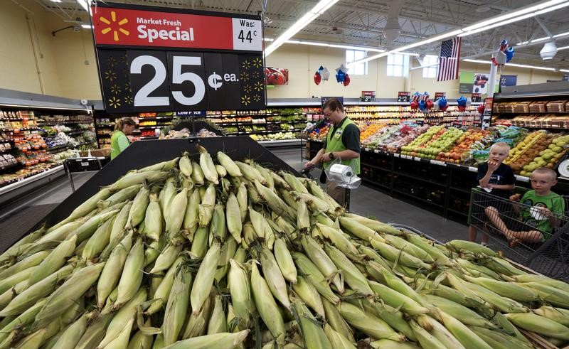 © Reuters. An employee works in the fresh produce department with a mound of sweet corn at the Wal-Mart Supercenter in Springdale