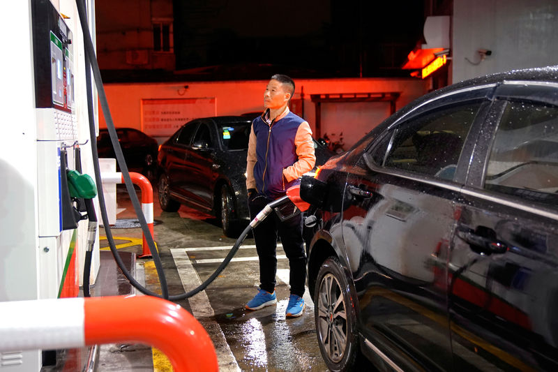 © Reuters. A driver looks at the price as he fills the tank of his car at a gas station in Shanghai