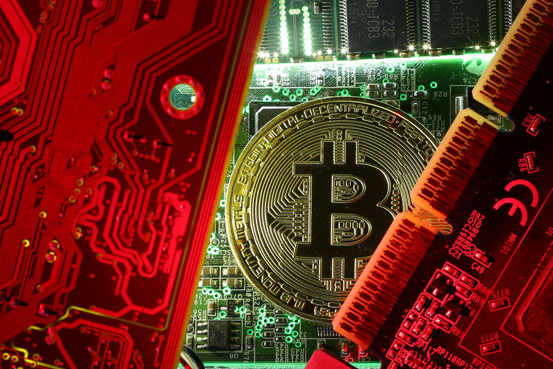 © Reuters. FILE PHOTO: A coin representing the bitcoin cryptocurrency is seen on computer circuit boards in this illustration picture