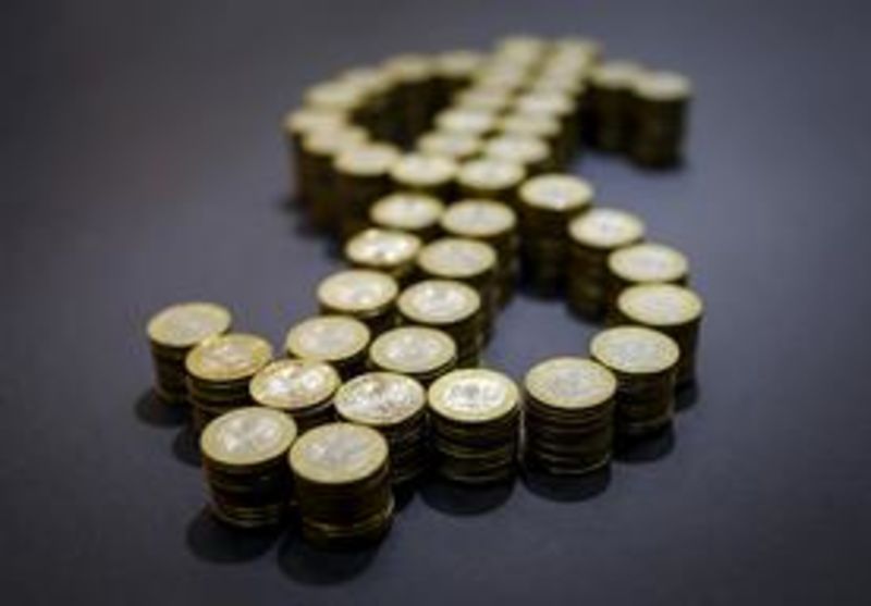 © Reuters. Знак доллара, выложенный монетами в 100 тенге.