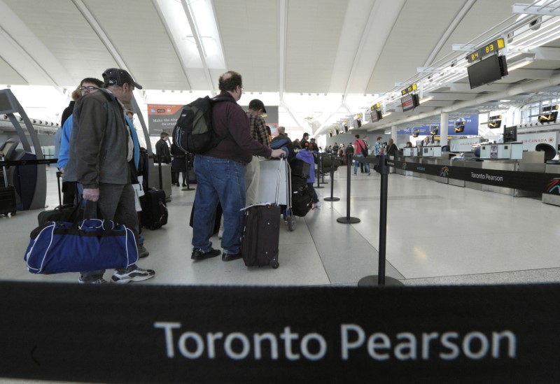 © Reuters. Air Canada passengers line-up at the baggage check-in counter at Pearson International Airport in Toronto