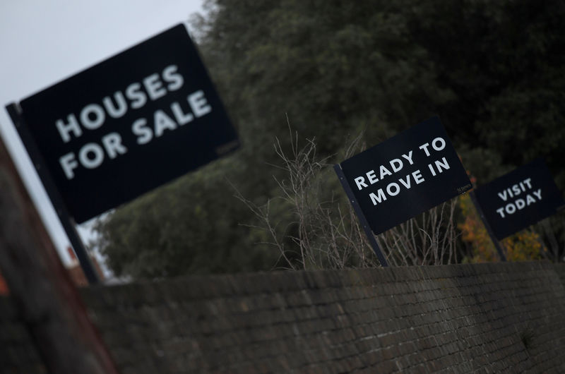 © Reuters. FILE PHOTO: Property sale signs are seen outside of a group of newly built houses in west London