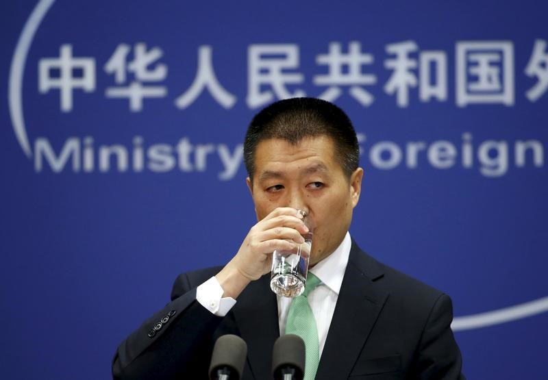 © Reuters. Chinese Foreign Ministry spokesman Lu Kang drinks a cup of water at a regular news conference in Beijing