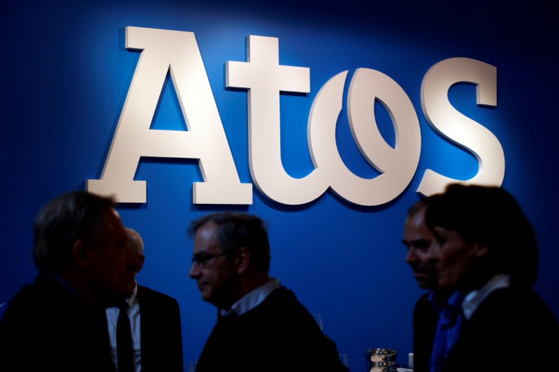 © Reuters. FILE PHOTO -  People walk in front of the Atos company's logo during a presentation of the new Bull sequana supercomputer in Paris