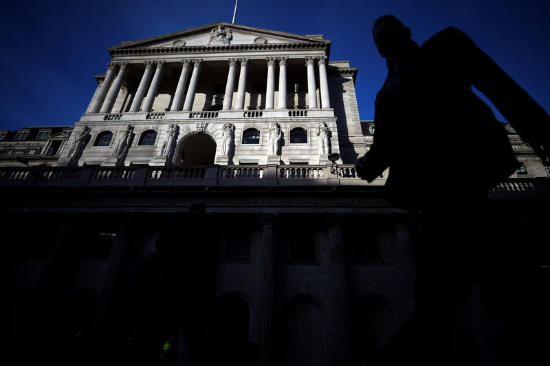 © Reuters. A man is silhouetted as he walks past the Bank of England in the City of London