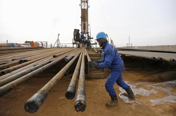 © Reuters. Рабочие готовят оборудование для добычи нефти на месторождении компании Разведка Добыча Казмунайгаз в Кызылординской области Казахстана
