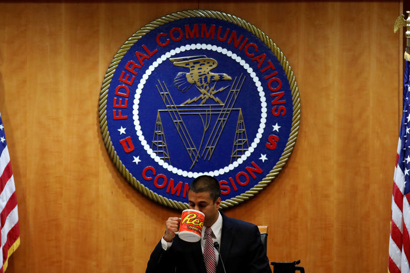 © Reuters. Chairman Ajit Paid drinks coffee ahead of the vote on the repeal of so called net neutrality rules at the Federal Communications Commission in Washington