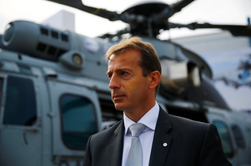 © Reuters. Airbus Helicopters CEO Guillaume Faury stands near a multi-role military helicopter EC 725 by Airbus Helicopters at an international military fair in Kielce