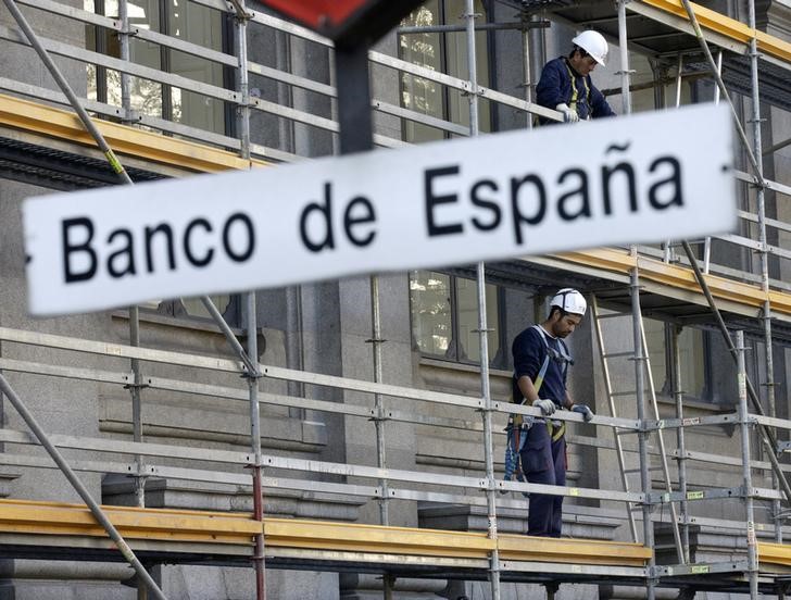 © Reuters. Construction workers stand on a scaffolding at the Bank of Spain in central Madrid, Spain