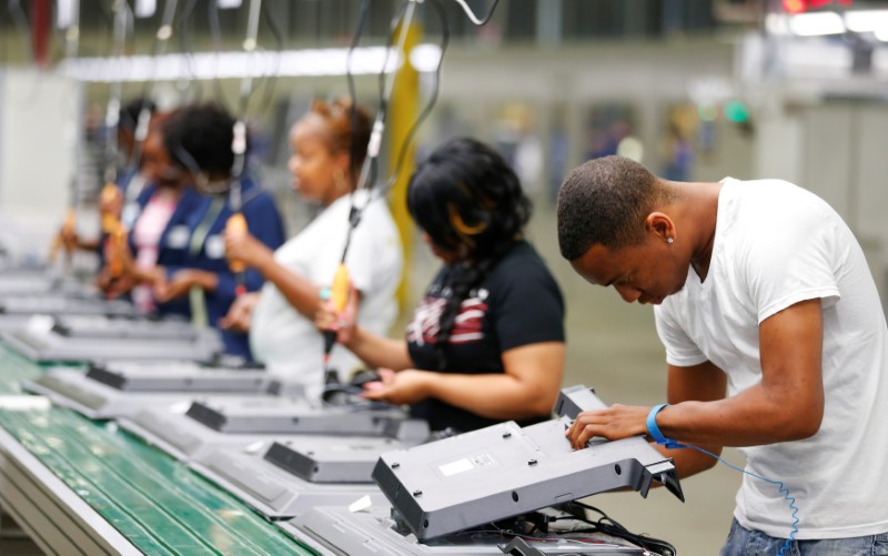 © Reuters. FILE PHOTO: Workers on the assembly line replace the back covers of 32-inch TV sets at Element Electronics in Winnsboro