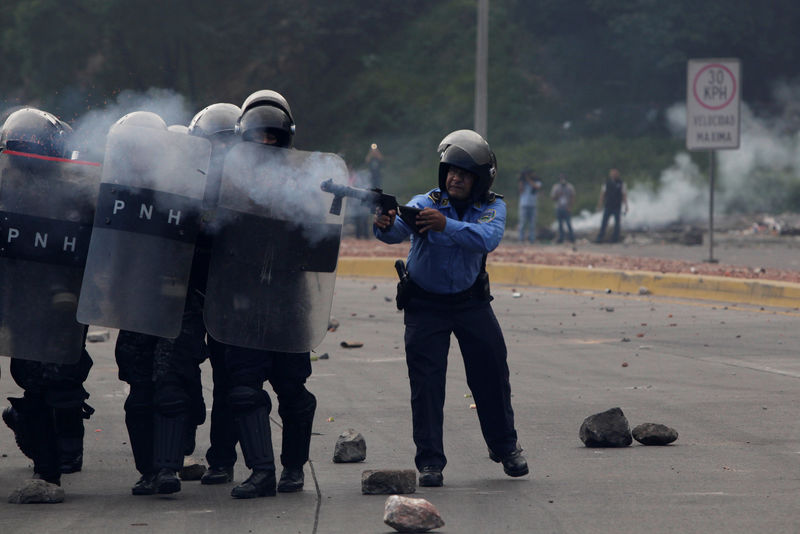 © Reuters. Police fire tear gas towards opposition supporters during a protest over a disputed presidential election in Tegucigalpa