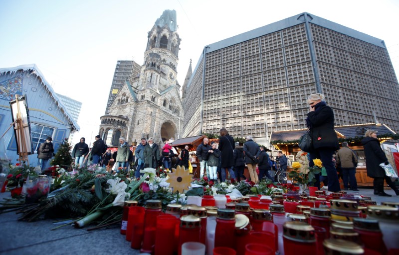 © Reuters. Flowers and candles are placed at the Christmas market at Breitscheid square in Berlin