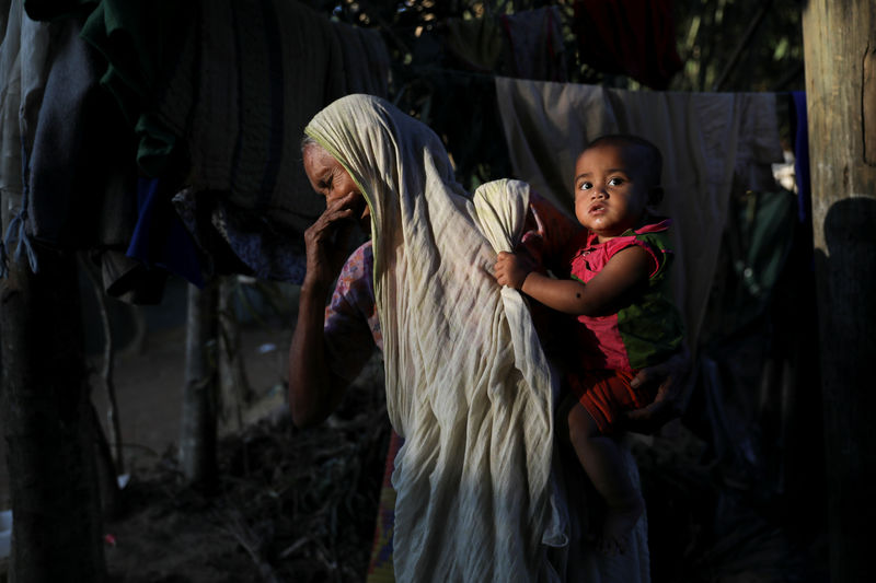 © Reuters. A Rohingya Hindu refugee woman holds a child inside their temporary shelter at the Kutupalong Hindu refugee camp near Cox's Bazar