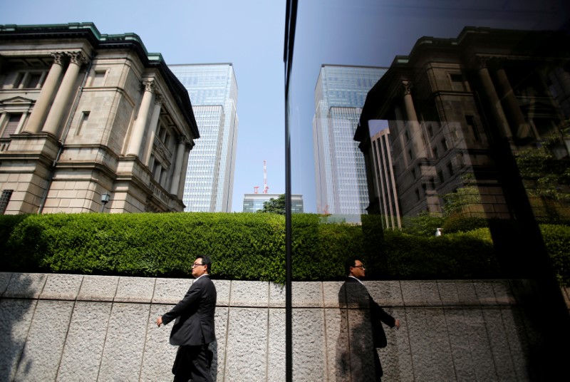© Reuters. Pedestrian walks past the Bank of Japan building in Tokyo