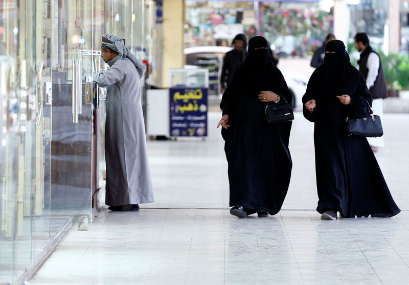 © Reuters. Women walk at a market in Riyadh