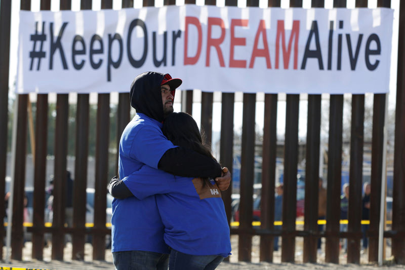 © Reuters. 'Dreamers' hug as they meet with relatives during the 'Keep Our Dream Alive' binational meeting at a new section of the border wall on the U.S.-Mexico border in Sunland Park