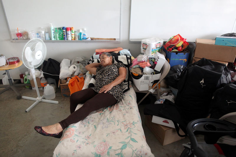 © Reuters. A woman who lost her home during Hurricane Maria in September rests on a cot at a school turned shelter during a visit of former U.S. President Clinton (not pictured), in Canovanas