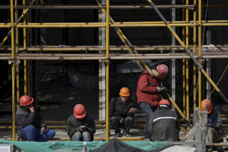 © Reuters. Workers rest after lunch at a construction site in Shanghai