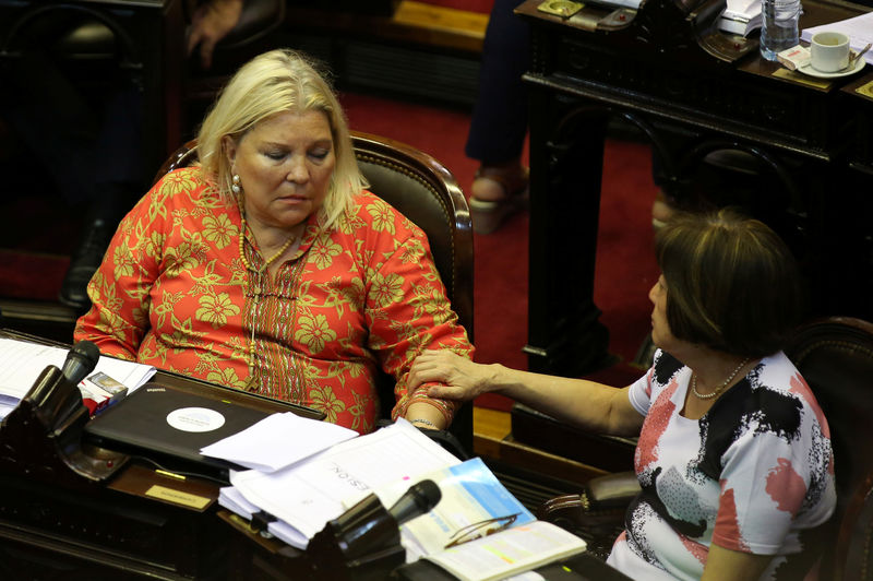 © Reuters. La diputada Alicia Terada habla con su colega Elisa Carrió (izquierda) durante el debate de la reforma de pensiones en Buenos Aires