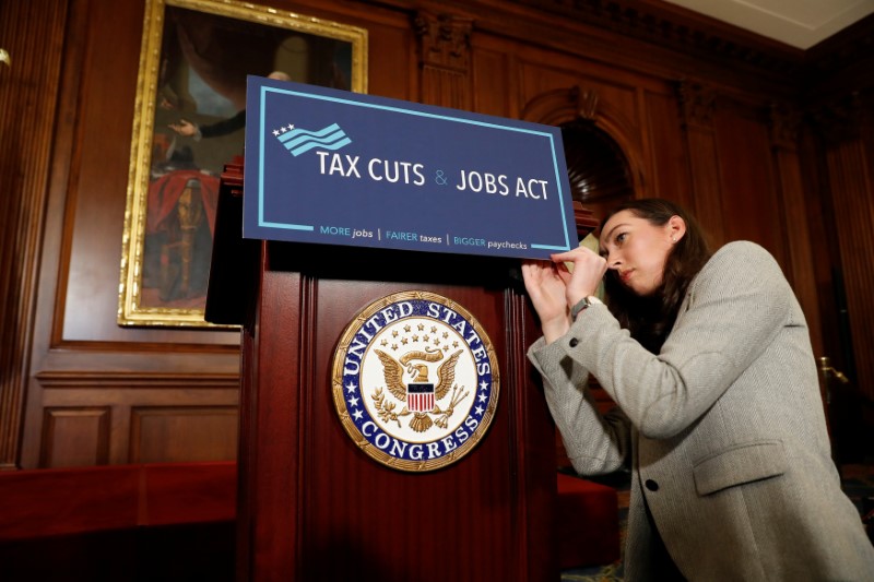 © Reuters. An aide adjusts a sign prior to a news conference announcing the passage of the "Tax Cuts and Jobs Act" at the U.S. Capitol in Washington