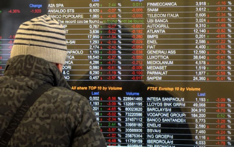 © Reuters. Un uomo guarda uno schermo con le quotazioni della Borsa di Milano