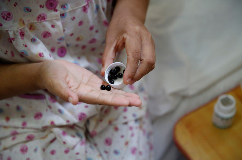 © Reuters. FILE PHOTO: A woman takes her medicine in Beijing