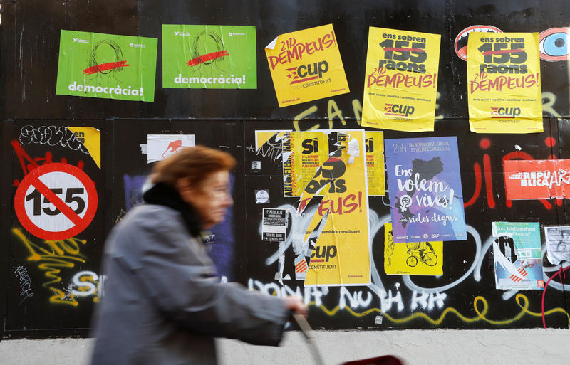 © Reuters. Mulher passa por cartazes de campanha eleitoral em Barcelona, Espanha